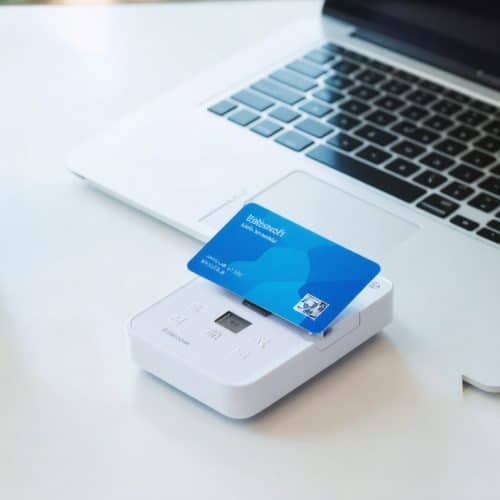 Ordinateur portable et lecteur de carte professionnelle sur le bureau d’un praticien libéral